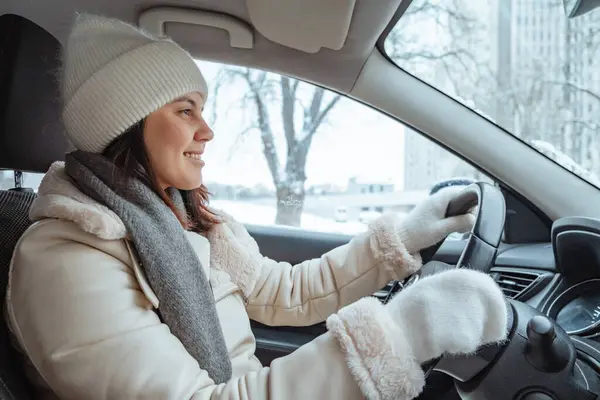 happy smiling woman in winter outfit driving car