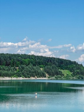 Mutlu adam gölün ortasındaki fotokopi odasında güneşlenerek yatar.