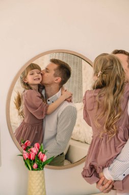 Baba ve kızı aynada yansıyor.