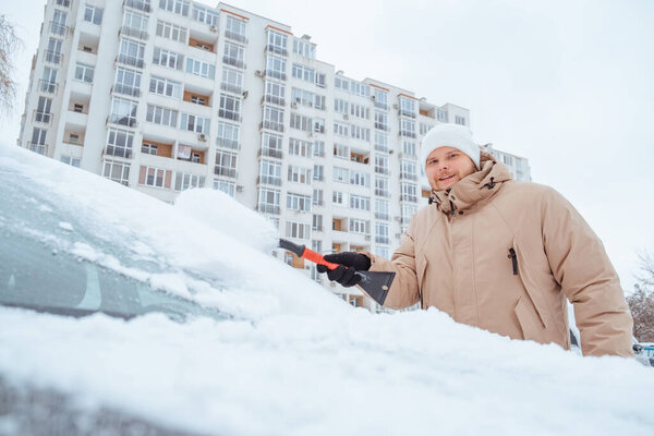 man cleaning car out of snow close up copy space