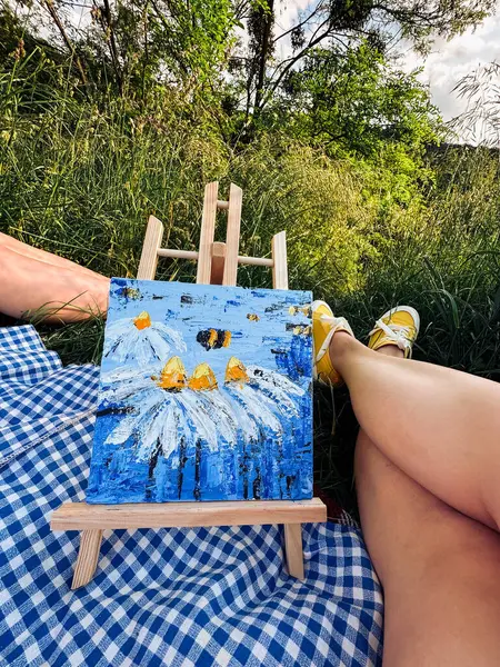 Engaging in artistic pursuits during a picnic in park.