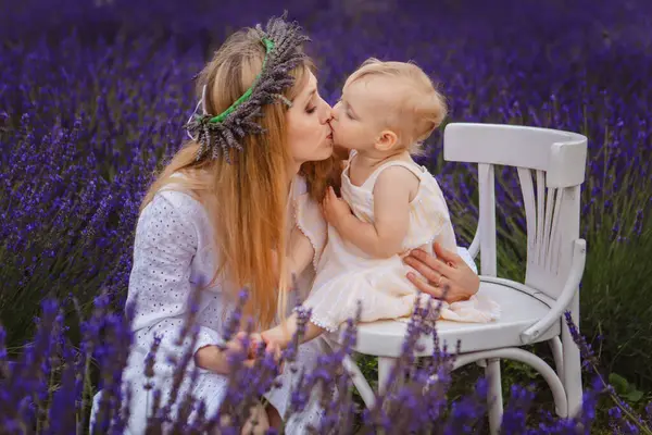 Mother Lavender Wreath Kisses Her Daughter Who Sitting White Chair — Stock Photo, Image