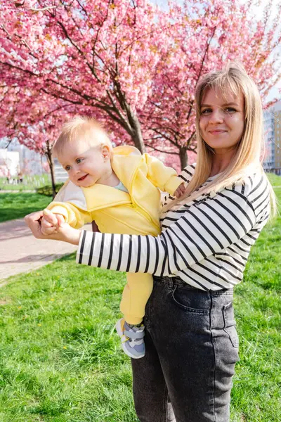 Kiraz çiçeklerinin altında anne ve bebek arasındaki tatlı an..