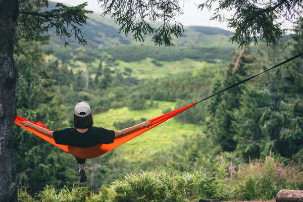 happy woman on hammock mountains on background copy space
