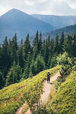 Sırt çantalı kadın dağlarda geziniyor. Boşluğu kopyala.