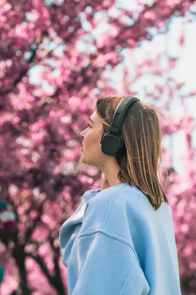 Stijlvolle Vrouw Meloman Luisteren Muziek Kopiëren Ruimte Bloeiende Sakura Achtergrond Stockfoto