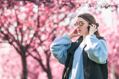 Tarz sahibi kadın meloman müzik dinliyor. Arka planda sakura açan boşluğu kopyalıyor.