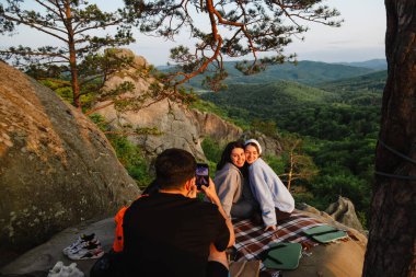 Mutlu arkadaşlar uçurumda pizza yiyorlar güzel Karpat dağ manzaralı