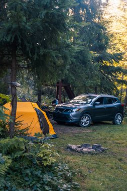 Dağ ormanında Cip ve Sarı Çadır ile Kamp Sahnesi