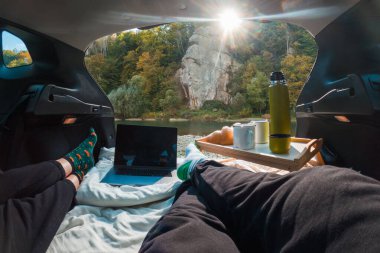 Nehir kenarında konforlu araba inzivaya çekildi. Piknik yapıyorlar.