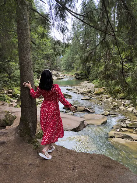 Serene Forest River 'ın yanındaki Kırmızı Elbiseli Gülümseyen Kadın