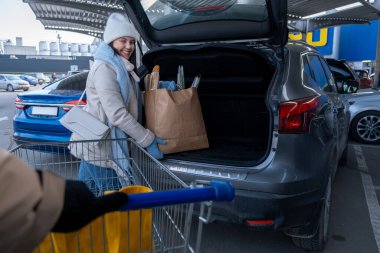 Kadın alışveriş konseptine yiyecek yüklüyor.
