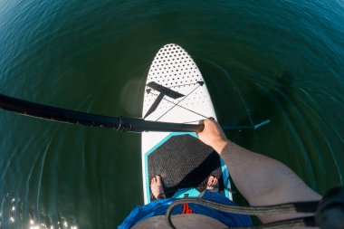 person perspective Paddleboarding on Calm Waters clipart