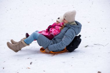 Gülümseyen anne ve çocuk Karlı Tepe 'de kızak kayıyor