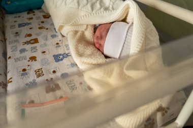 Yeni doğan bebek örgü örülmüş battaniyede uyuyor Kopya alanı