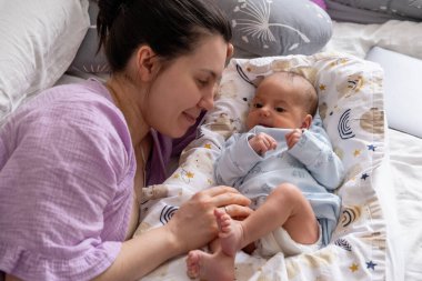 Anne ve Bebek Yatakta Birlikte Rahatlıyor.