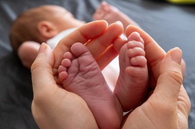 Hassas an: Yetişkin Elleri Yeni Doğmuş Bebek Ayaklarını Tutuyor Yaklaş