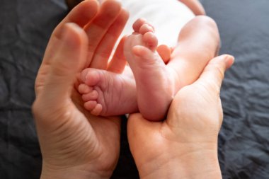 Hassas an: Yetişkin Elleri Yeni Doğmuş Bebek Ayaklarını Tutuyor Yaklaş