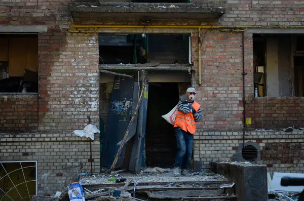 24 Nisan 2025 'te Kyiv' in Sviatoshynskyi ilçesinde Rus roketi yangınından zarar gören bir evin parçalarını taşıyan bir adam görülüyor..