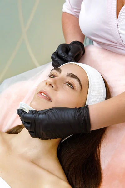 Kozmetik servisi, kozmetik terapisi, cilt temizleme, yüz bakımı, güzellik tedavisi, yüz yenileme tedavisi, kozmetologlarda yüz masajı. Pamuk pedlerle temizlik