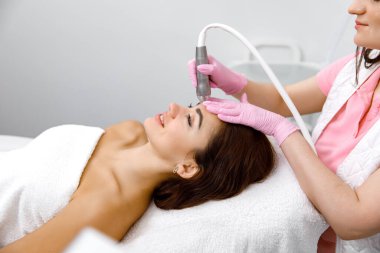 Cilt bakımı, yüz bakımı, yüz bakımı, akne terapisi, cilt yenileme, cilt bakımı. Bir kozmetikçide yüz muayenesi.