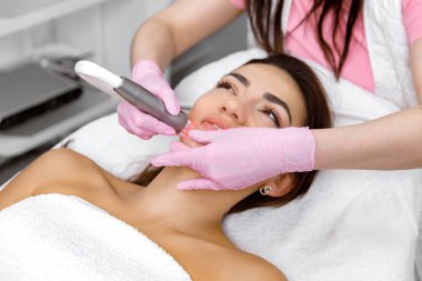 Siyah başlık kaldırma, kozmetik servisi, estetik prosedür, kozmetik uzmanı estetik kliniğinde bir müşteri için yüz bakımı yapıyor.