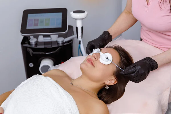 Facial rejuvenation, Dermatology Services, Beauty Skin Care, Cotton pads on the eyes, preparation for a cosmetic procedure. doctor performs a rejuvenation procedure for a woman. IPL procedure
