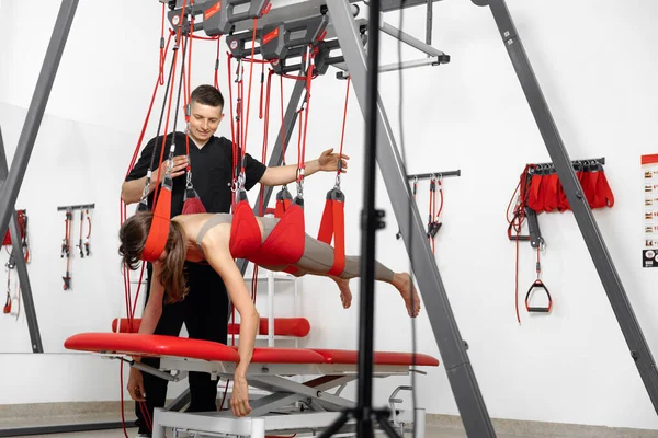 physical therapy, Physical rehabilitation, Health-improving exercises, doing exercises, decompression simulators. Rehabilitation exercises on red cord slings to restore pain-free movement patterns and