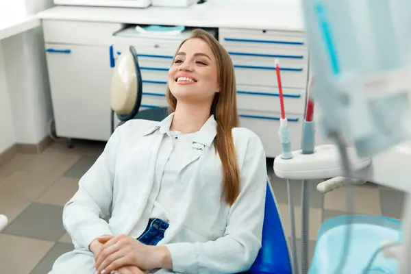 Gülümseyen dişçi hasta, sağlıklı gülümseme, dişçi konsepti, dişçilik kliniği, kameraya gülümseyen güzel kadın.