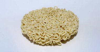 Beyaz arka planda çiğ erişte, yuvarlak hazır erişte.