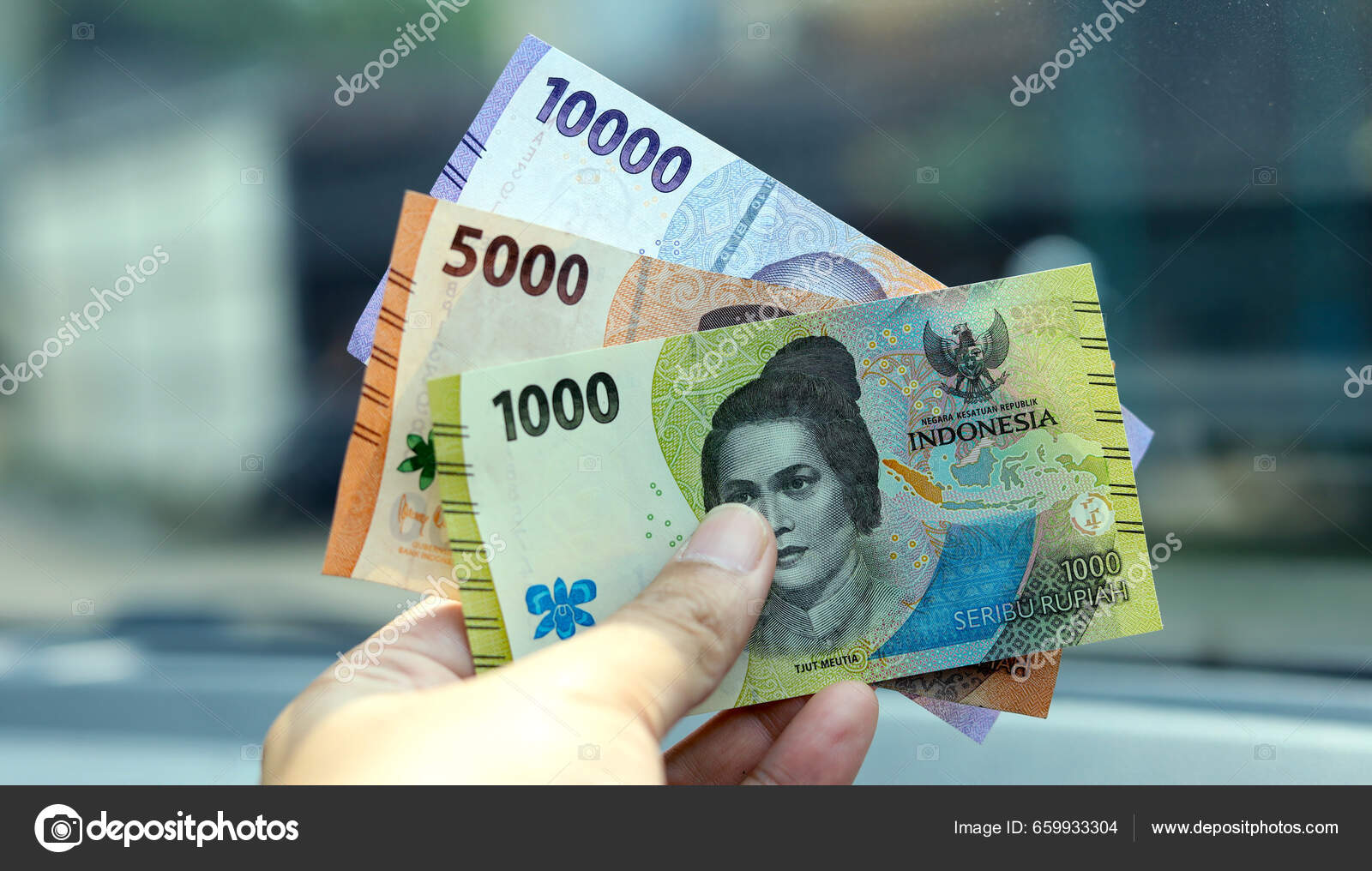 インドネシア人男性の手はルピアのお金を保持 インドネシア通貨 現金を手に入れビューを閉じて — ストック写真 © sadytom@gmail.com  #659933304