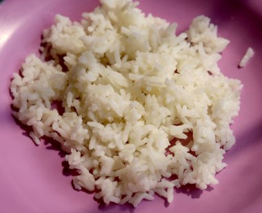 Mor tabakta pişmiş beyaz pirinç. Yukarıdan görüntüle ve kapat
