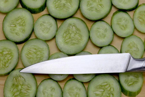 木のまな板にナイフで新鮮なスライスキュウリ — ストック写真