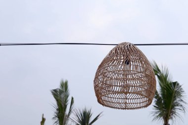 Kabloda asılı sanatsal dekoratif bambu sepeti lambası.