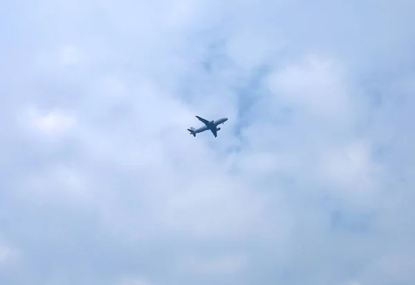 Gökyüzünde bulutların üzerinde uçan bir uçak.