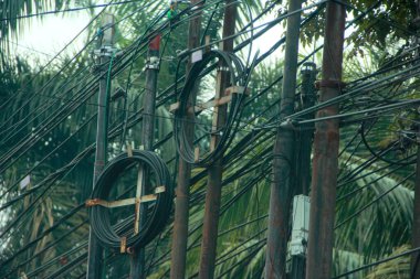 Caddedeki direğe elektrik kabloları dolanmış.
