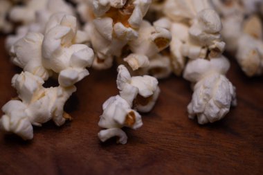 Kabarık hafif altın patlamış mısırları koyu ahşap servis tepsisine yakın tut.