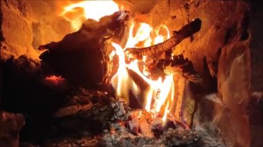 Alevler taştan bir şöminenin içinde dans ediyor. Etrafında hafif bir parıltı bırakıyor. Ateşin sıcaklığı rahatlamaya ve rahatlamaya davetiye çıkarır. Kış geceleri için mükemmeldir..