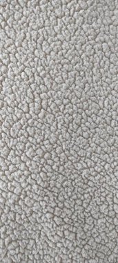 Yumuşak beyaz şerpa yün kumaşının yüksek çözünürlüklü yakın çekimi. Konforlu ev dekorasyonu, kışlık moda kıyafetleri, sürdürülebilir tekstil ve modern minimalist iç tasarım projeleri için mükemmel..
