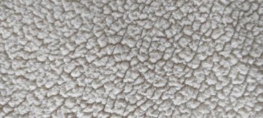 Tüylü bej şerpa kumaş dokusunun detaylı makro çekimi. Çevre dostu döşemeler, İskandinav tarzı mobilyalar, modern iç mekan ve sürdürülebilir tekstil tasarımları için ideal..