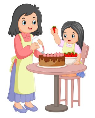 Anne ve kızı resimleme mutfağında birlikte kek pişiriyorlar.