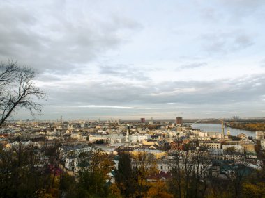 Dnipro Nehri manzarası ve şehir merkezindeki sarı ağaçlar. Tarihi mimari ve manzara, Kyiv 'in doğası. Sonbaharda Ukrayna 'nın başkenti Kyiv' de. Güzel gökyüzü.