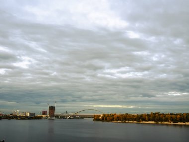 Dnipro Nehri manzarası ve şehir merkezindeki sarı ağaçlar. Tarihi mimari ve manzara, Kyiv 'in doğası. Sonbaharda Ukrayna 'nın başkenti Kyiv' de. Güzel gökyüzü.