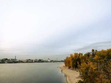 Dnipro Nehri manzarası ve şehir merkezindeki sarı ağaçlar. Tarihi mimari ve manzara, Kyiv 'in doğası. Sonbaharda Ukrayna 'nın başkenti Kyiv' de. Güzel gökyüzü.