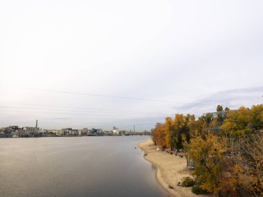 Dnipro Nehri manzarası ve şehir merkezindeki sarı ağaçlar. Tarihi mimari ve manzara, Kyiv 'in doğası. Sonbaharda Ukrayna 'nın başkenti Kyiv' de. Güzel gökyüzü.