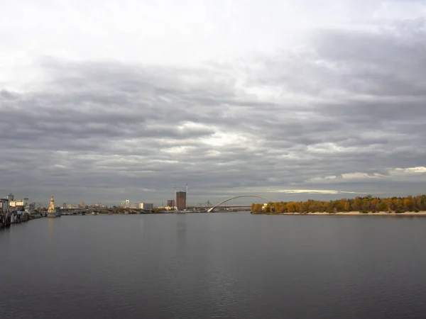 Dnipro Nehri manzarası ve şehir merkezindeki sarı ağaçlar. Tarihi mimari ve manzara, Kyiv 'in doğası. Sonbaharda Ukrayna 'nın başkenti Kyiv' de. Güzel gökyüzü.
