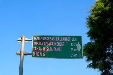 Wonosobo Meydanı 'ndaki trafik kontrol panosu için yeşil yol tabelası ya da sokak tabelası. Taman rekreasi kali anget, telaga menjer, taman wisata tambi, dieng işaretleri var.
