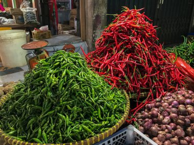 Geleneksel yemek malzemeleri pazarında taze kırmızı biber, yeşil biber ve soğan yığını..