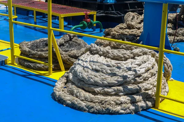 Mooring rope on the deck of commercial ship. Mechanical device equipment for ship mooring in port.