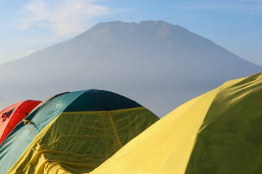 Mount andong 'un tepesinde kamp alanı. Altın saat boyunca dağın zirvesinde birçok çadır ve dağcı.